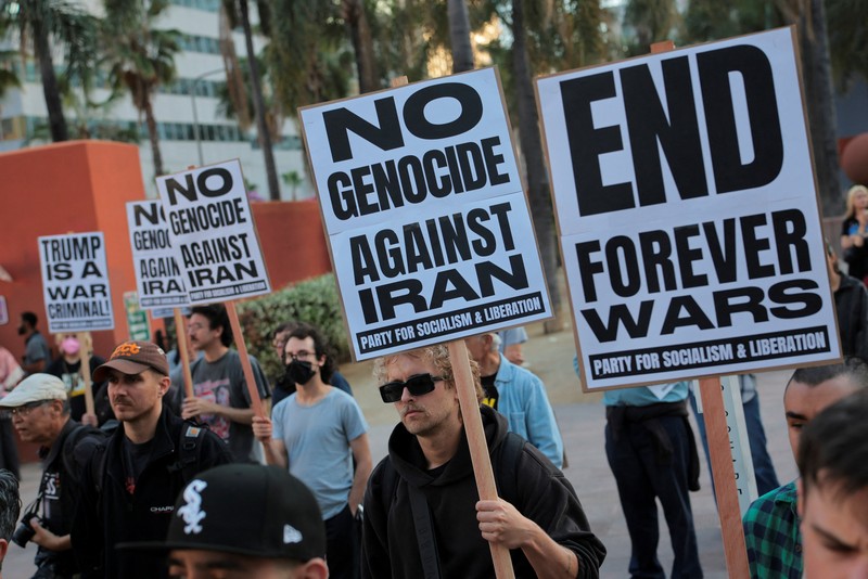 Seorang demonstran membawa potret mendiang Pemimpin Tertinggi Iran Ayatollah Ali Khamenei selama protes menentang aksi militer di Iran dekat Gedung Putih di Washington, D.C., AS, 8 April 2026. (REUTERS/Evelyn Hockstein)