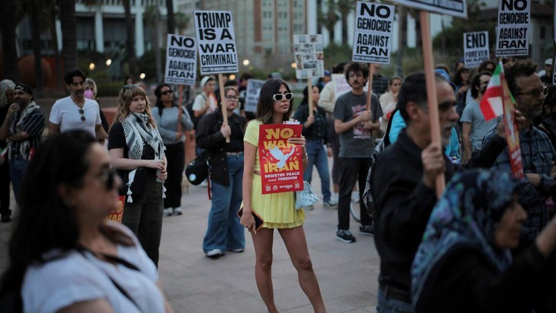 Seorang demonstran membawa potret mendiang Pemimpin Tertinggi Iran Ayatollah Ali Khamenei selama protes menentang aksi militer di Iran dekat Gedung Putih di Washington, D.C., AS, 8 April 2026. (REUTERS/Evelyn Hockstein)