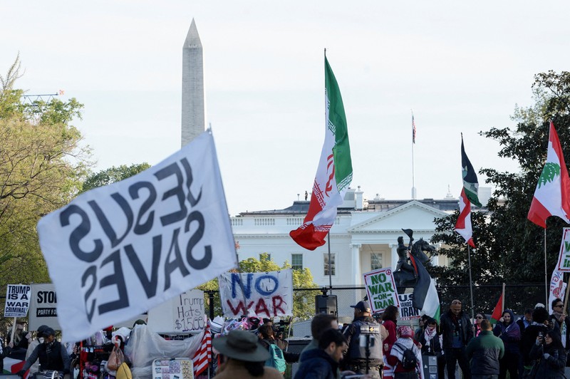 Seorang demonstran membawa potret mendiang Pemimpin Tertinggi Iran Ayatollah Ali Khamenei selama protes menentang aksi militer di Iran dekat Gedung Putih di Washington, D.C., AS, 8 April 2026. (REUTERS/Evelyn Hockstein)
