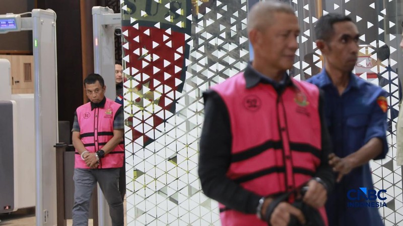 Tersangka kasus korupsi tata kelola minyak mentah berjalan menuju mobil tahanan di gedung Kejaksaan Agung, Jakarta, Kamis (9/4/2026) malam. (CNBC Indonesia/Muhammad Sabki)