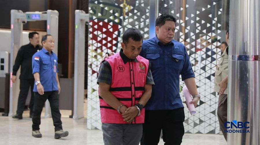 Tersangka kasus korupsi tata kelola minyak mentah berjalan menuju mobil tahanan di gedung Kejaksaan Agung, Jakarta, Kamis (9/4/2026) malam. (CNBC Indonesia/Muhammad Sabki)