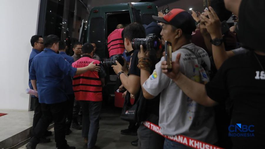 Tersangka kasus korupsi tata kelola minyak mentah berjalan menuju mobil tahanan di gedung Kejaksaan Agung, Jakarta, Kamis (9/4/2026) malam. (CNBC Indonesia/Muhammad Sabki)