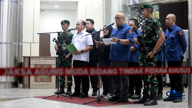 Petugas mendampingi tersangka perkara dugaan pengadaan minyak mentah dan produk kilang Irawan Prakoso (tengah) seusai menjalani pemeriksaan di Kejaksaan Agung, Jakarta, Kamis (9/4/2026). Kejaksaan Agung menetapkan tujuh tersangka dalam kasus dugaan korupsi pengadaan minyak mentah dan produk kilang di Pertamina Energy Trading Limited (Petral) atau Pertamina Energy Services (PES) Pte Ltd. (CNBC Indonesia/Muhammad Sabki)