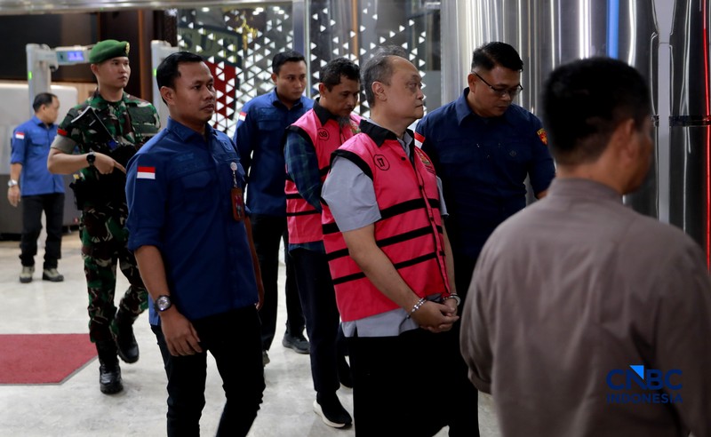 Petugas mendampingi tersangka perkara dugaan pengadaan minyak mentah dan produk kilang Irawan Prakoso (tengah) seusai menjalani pemeriksaan di Kejaksaan Agung, Jakarta, Kamis (9/4/2026). Kejaksaan Agung menetapkan tujuh tersangka dalam kasus dugaan korupsi pengadaan minyak mentah dan produk kilang di Pertamina Energy Trading Limited (Petral) atau Pertamina Energy Services (PES) Pte Ltd. (CNBC Indonesia/Muhammad Sabki)