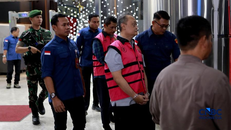 Petugas mendampingi tersangka perkara dugaan pengadaan minyak mentah dan produk kilang Irawan Prakoso (tengah) seusai menjalani pemeriksaan di Kejaksaan Agung, Jakarta, Kamis (9/4/2026). Kejaksaan Agung menetapkan tujuh tersangka dalam kasus dugaan korupsi pengadaan minyak mentah dan produk kilang di Pertamina Energy Trading Limited (Petral) atau Pertamina Energy Services (PES) Pte Ltd. (CNBC Indonesia/Muhammad Sabki)