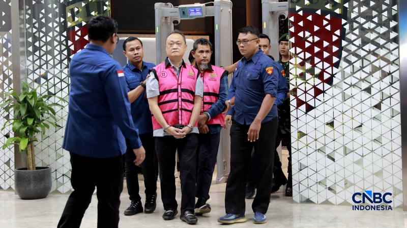 Petugas mendampingi tersangka perkara dugaan pengadaan minyak mentah dan produk kilang Irawan Prakoso (tengah) seusai menjalani pemeriksaan di Kejaksaan Agung, Jakarta, Kamis (9/4/2026). Kejaksaan Agung menetapkan tujuh tersangka dalam kasus dugaan korupsi pengadaan minyak mentah dan produk kilang di Pertamina Energy Trading Limited (Petral) atau Pertamina Energy Services (PES) Pte Ltd. (CNBC Indonesia/Muhammad Sabki)