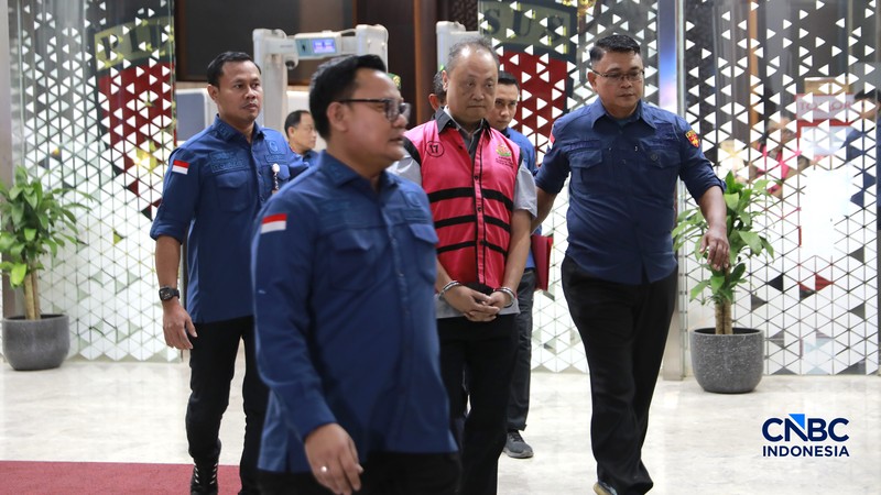 Petugas mendampingi tersangka perkara dugaan pengadaan minyak mentah dan produk kilang Irawan Prakoso (tengah) seusai menjalani pemeriksaan di Kejaksaan Agung, Jakarta, Kamis (9/4/2026). Kejaksaan Agung menetapkan tujuh tersangka dalam kasus dugaan korupsi pengadaan minyak mentah dan produk kilang di Pertamina Energy Trading Limited (Petral) atau Pertamina Energy Services (PES) Pte Ltd. (CNBC Indonesia/Muhammad Sabki)