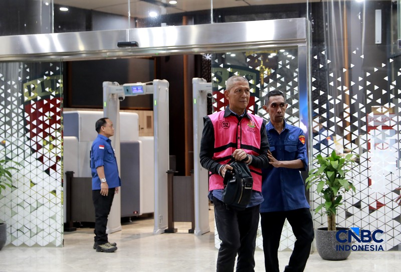 Petugas mendampingi tersangka perkara dugaan pengadaan minyak mentah dan produk kilang Irawan Prakoso (tengah) seusai menjalani pemeriksaan di Kejaksaan Agung, Jakarta, Kamis (9/4/2026). Kejaksaan Agung menetapkan tujuh tersangka dalam kasus dugaan korupsi pengadaan minyak mentah dan produk kilang di Pertamina Energy Trading Limited (Petral) atau Pertamina Energy Services (PES) Pte Ltd. (CNBC Indonesia/Muhammad Sabki)