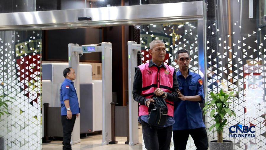 Petugas mendampingi tersangka perkara dugaan pengadaan minyak mentah dan produk kilang Irawan Prakoso (tengah) seusai menjalani pemeriksaan di Kejaksaan Agung, Jakarta, Kamis (9/4/2026). Kejaksaan Agung menetapkan tujuh tersangka dalam kasus dugaan korupsi pengadaan minyak mentah dan produk kilang di Pertamina Energy Trading Limited (Petral) atau Pertamina Energy Services (PES) Pte Ltd. (CNBC Indonesia/Muhammad Sabki)