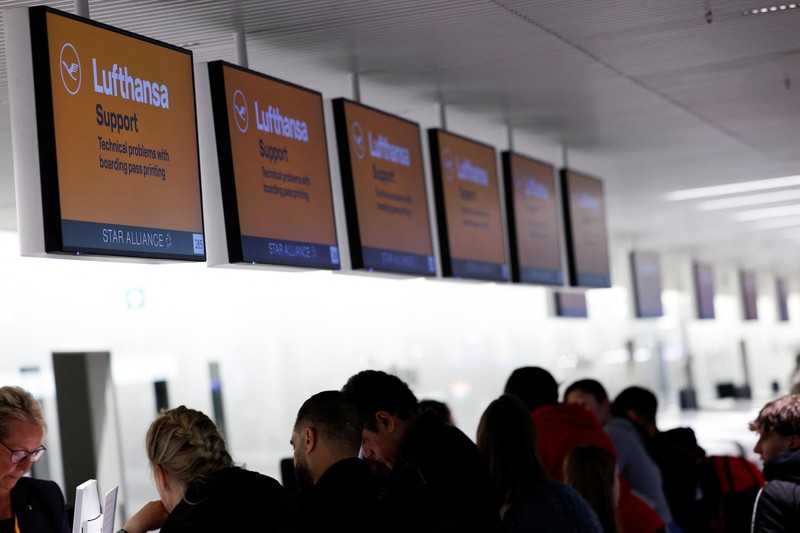 Orang-orang melihat papan informasi yang menampilkan penerbangan, yang sebagian besar dibatalkan, selama pemogokan oleh serikat UFO, yang mewakili awak kabin Lufthansa, di Bandara Frankfurt, Jerman, 10 April 2026. (REUTERS/Heiko Becker)