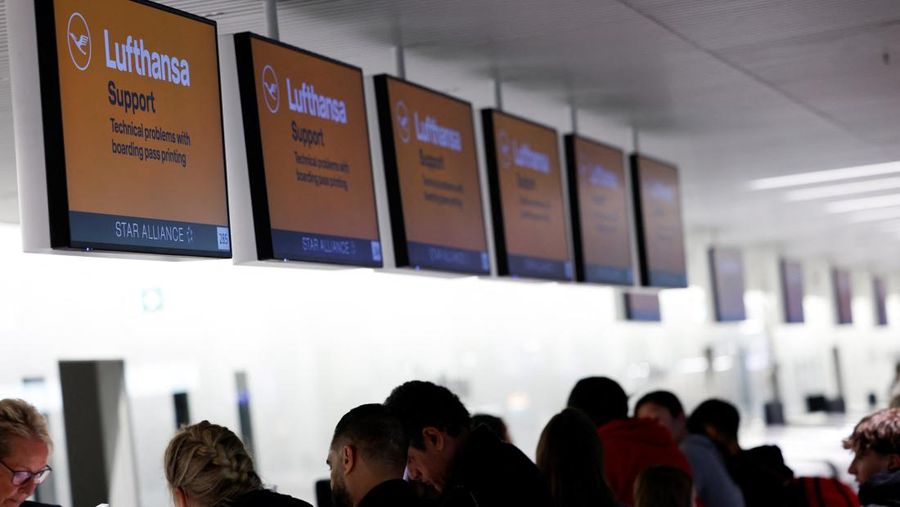 Orang-orang melihat papan informasi yang menampilkan penerbangan, yang sebagian besar dibatalkan, selama pemogokan oleh serikat UFO, yang mewakili awak kabin Lufthansa, di Bandara Frankfurt, Jerman, 10 April 2026. (REUTERS/Heiko Becker)