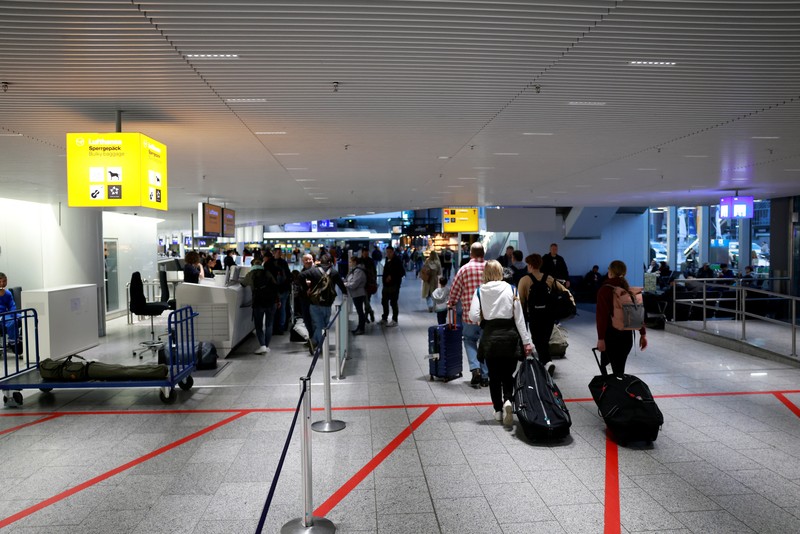 Orang-orang melihat papan informasi yang menampilkan penerbangan, yang sebagian besar dibatalkan, selama pemogokan oleh serikat UFO, yang mewakili awak kabin Lufthansa, di Bandara Frankfurt, Jerman, 10 April 2026. (REUTERS/Heiko Becker)