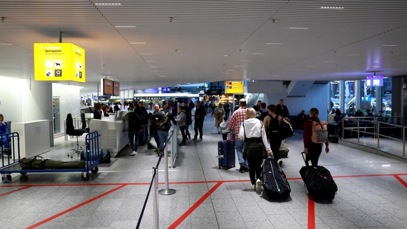 Orang-orang melihat papan informasi yang menampilkan penerbangan, yang sebagian besar dibatalkan, selama pemogokan oleh serikat UFO, yang mewakili awak kabin Lufthansa, di Bandara Frankfurt, Jerman, 10 April 2026. (REUTERS/Heiko Becker)