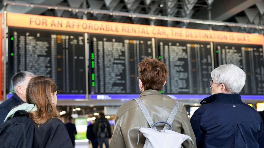 Orang-orang melihat papan informasi yang menampilkan penerbangan, yang sebagian besar dibatalkan, selama pemogokan oleh serikat UFO, yang mewakili awak kabin Lufthansa, di Bandara Frankfurt, Jerman, 10 April 2026. (REUTERS/Heiko Becker)