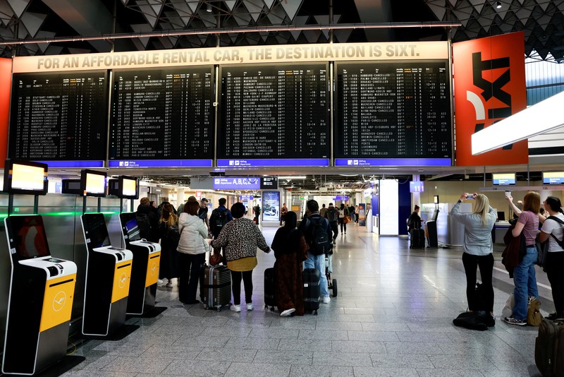 Orang-orang melihat papan informasi yang menampilkan penerbangan, yang sebagian besar dibatalkan, selama pemogokan oleh serikat UFO, yang mewakili awak kabin Lufthansa, di Bandara Frankfurt, Jerman, 10 April 2026. (REUTERS/Heiko Becker)