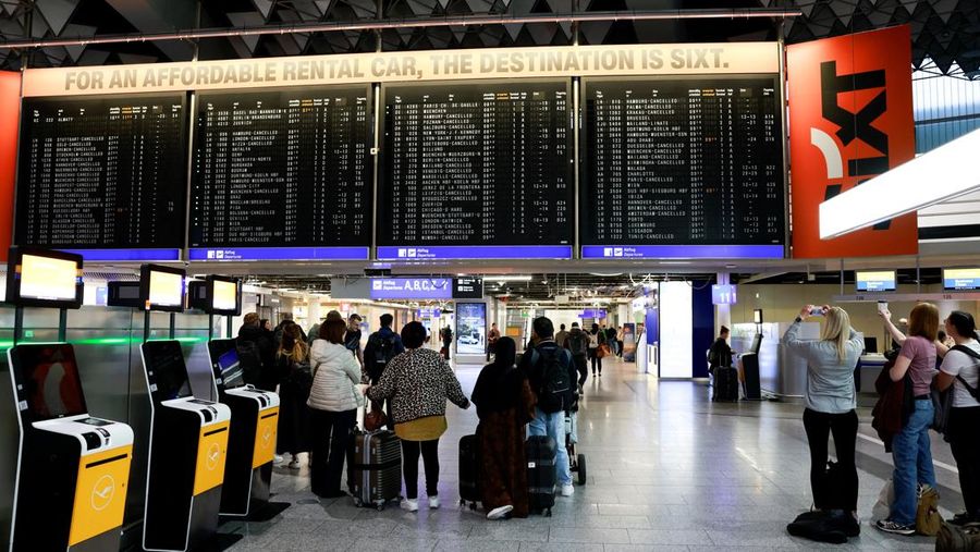 Orang-orang melihat papan informasi yang menampilkan penerbangan, yang sebagian besar dibatalkan, selama pemogokan oleh serikat UFO, yang mewakili awak kabin Lufthansa, di Bandara Frankfurt, Jerman, 10 April 2026. (REUTERS/Heiko Becker)