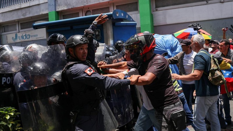 Para pekerja sektor publik bentrok dengan Kepolisian Nasional Bolivarian selama protes yang menuntut upah lebih tinggi dan kondisi kerja yang lebih baik, di Caracas, Venezuela, 9 April 2026. (REUTERS/Leonardo Fernandez Viloria)