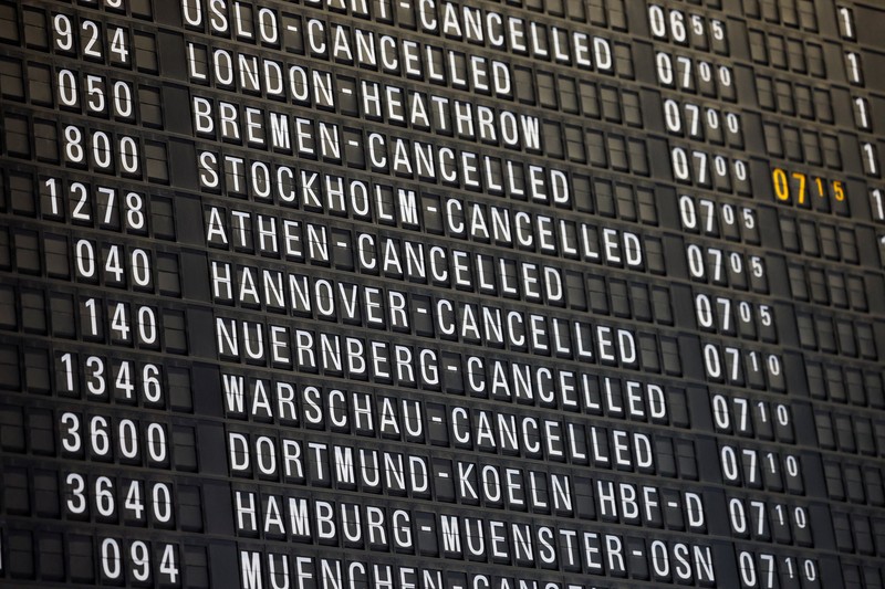 Orang-orang melihat papan informasi yang menampilkan penerbangan, yang sebagian besar dibatalkan, selama pemogokan oleh serikat UFO, yang mewakili awak kabin Lufthansa, di Bandara Frankfurt, Jerman, 10 April 2026. (REUTERS/Heiko Becker)