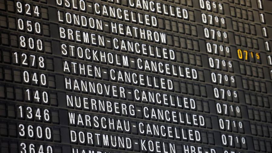 Orang-orang melihat papan informasi yang menampilkan penerbangan, yang sebagian besar dibatalkan, selama pemogokan oleh serikat UFO, yang mewakili awak kabin Lufthansa, di Bandara Frankfurt, Jerman, 10 April 2026. (REUTERS/Heiko Becker)