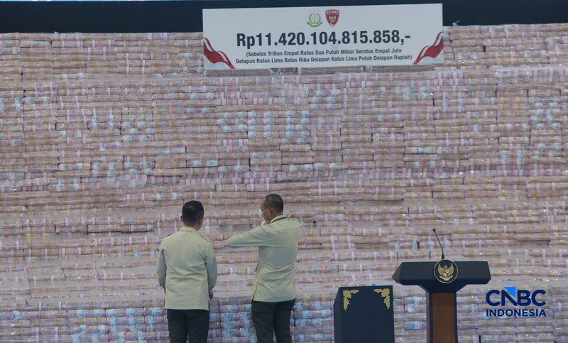 Sejumlah uang sitaan dalam Kegiatan Penyerahan Denda Administratif dan Penyelamatan Keuangan Negara Serta Penguasaan Kembali Kawasan Hutan Tahap VI Gedung Bundar Kejaksaan Agung, Jakarta, Jumat (10/04/2026). (CNBC Indonesia/Muhammad Sabki)
