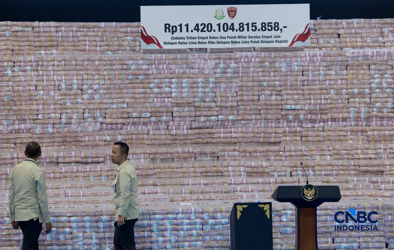 Sejumlah uang sitaan dalam Kegiatan Penyerahan Denda Administratif dan Penyelamatan Keuangan Negara Serta Penguasaan Kembali Kawasan Hutan Tahap VI Gedung Bundar Kejaksaan Agung, Jakarta, Jumat (10/04/2026). (CNBC Indonesia/Muhammad Sabki)
