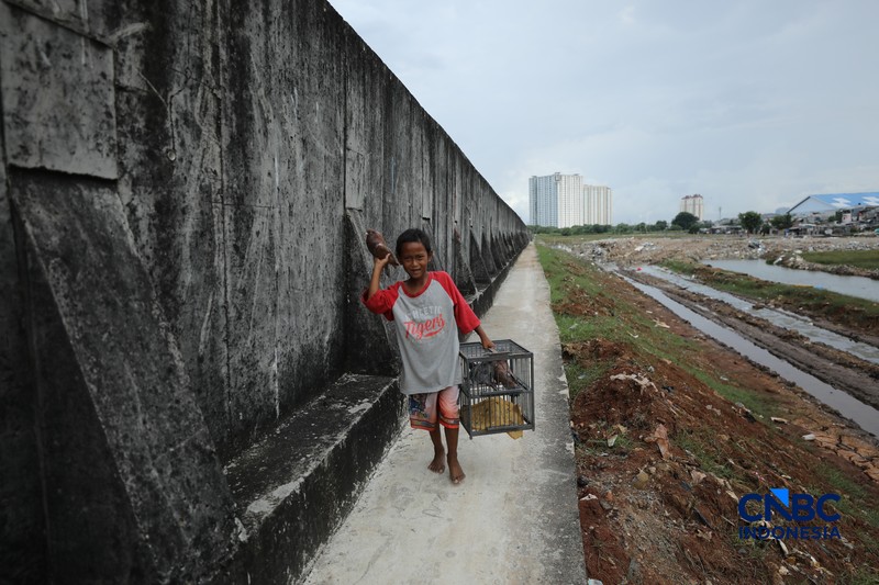 Sejumlah warga beraktivitas di area tanggul Pantai Muara Baru, Jakarta, Jumat (10/4/2026). (CNBC Indonesia/Tri Susilo)