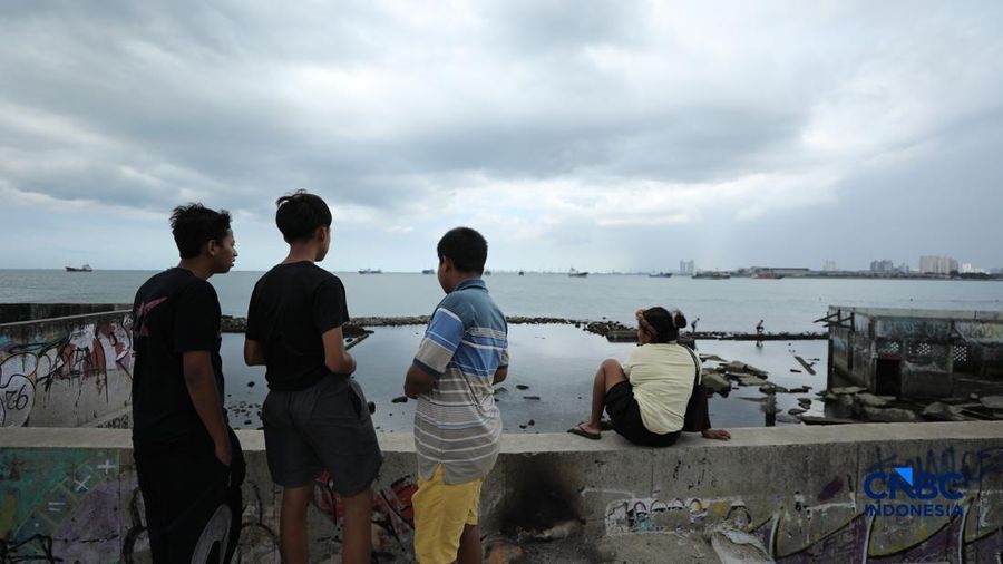 Sejumlah warga beraktivitas di area tanggul Pantai Muara Baru, Jakarta, Jumat (10/4/2026). (CNBC Indonesia/Tri Susilo)