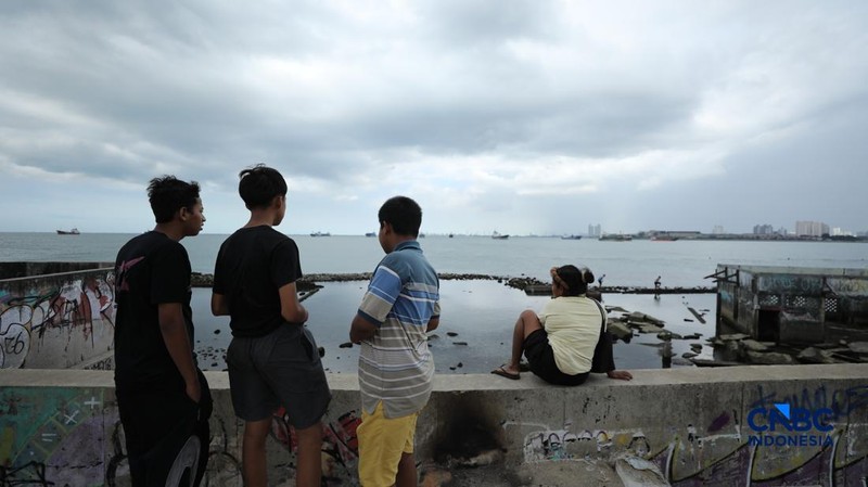 Sejumlah warga beraktivitas di area tanggul Pantai Muara Baru, Jakarta, Jumat (10/4/2026). (CNBC Indonesia/Tri Susilo)