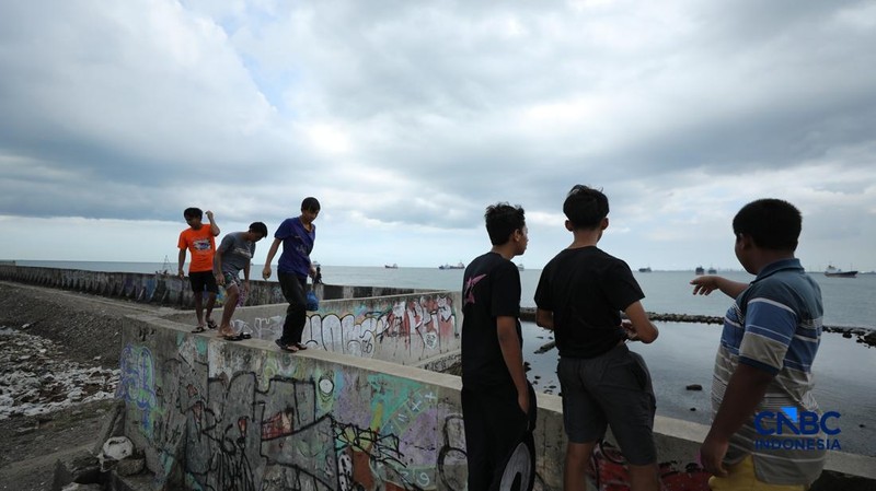 Sejumlah warga beraktivitas di area tanggul Pantai Muara Baru, Jakarta, Jumat (10/4/2026). (CNBC Indonesia/Tri Susilo)