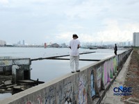 Sejumlah warga beraktivitas di area tanggul Pantai Muara Baru, Jakarta, Jumat (10/4/2026). (CNBC Indonesia/Tri Susilo)