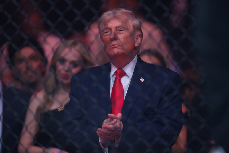 U.S. President Donald Trump and Hunter Campbell, chief business officer of the UFC, watch a match during the UFC 327 event at Kaseya Center in Miami, Florida, U.S., April 11, 2026.  REUTERS/Kevin Lamarque