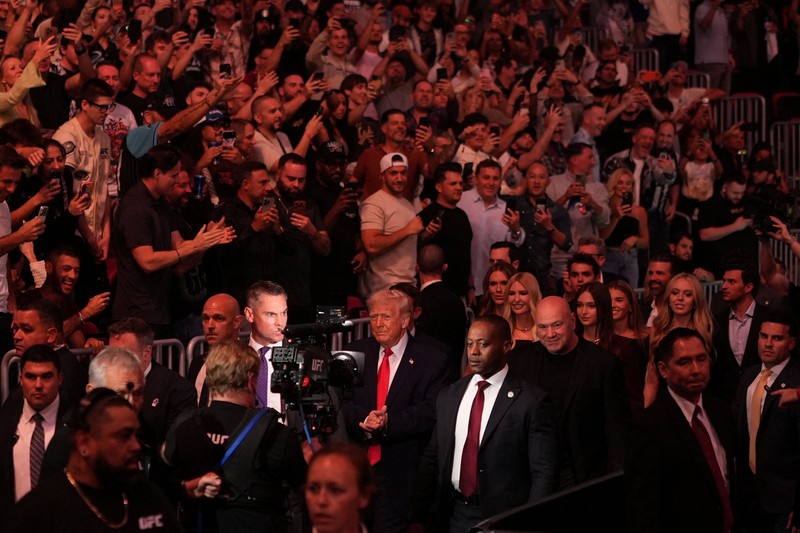 U.S. President Donald Trump and Hunter Campbell, chief business officer of the UFC, watch a match during the UFC 327 event at Kaseya Center in Miami, Florida, U.S., April 11, 2026.  REUTERS/Kevin Lamarque