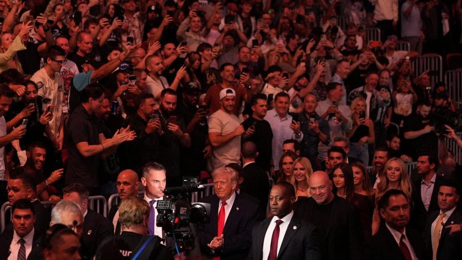 U.S. President Donald Trump and Hunter Campbell, chief business officer of the UFC, watch a match during the UFC 327 event at Kaseya Center in Miami, Florida, U.S., April 11, 2026.  REUTERS/Kevin Lamarque