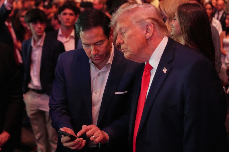 U.S. President Donald Trump and Hunter Campbell, chief business officer of the UFC, watch a match during the UFC 327 event at Kaseya Center in Miami, Florida, U.S., April 11, 2026.  REUTERS/Kevin Lamarque