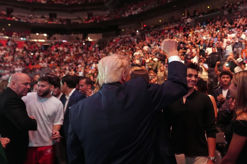 U.S. President Donald Trump and Hunter Campbell, chief business officer of the UFC, watch a match during the UFC 327 event at Kaseya Center in Miami, Florida, U.S., April 11, 2026.  REUTERS/Kevin Lamarque
