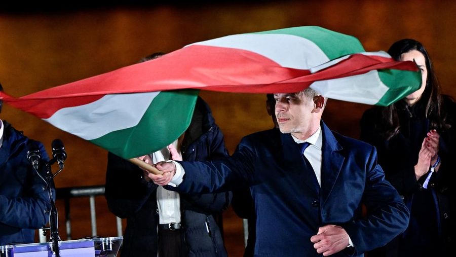Peter Magyar, leader of the opposition Tisza party, holds a flag following the partial results of the parliamentary election, in Budapest, Hungary, April 12, 2026. REUTERS/Marton Monus