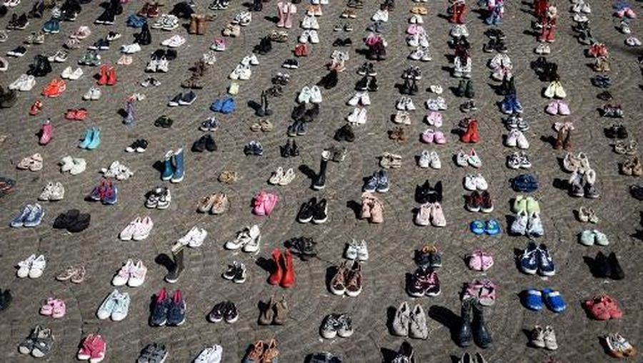 A photo shows children's shoes layed out on Dam Square during a memorial protest organised by Plant an Olive Tree group for child victims in Gaza, in Amsterdam, on April 12, 2026. (Photo by Ramon van Flymen / ANP / AFP) / Netherlands OUT