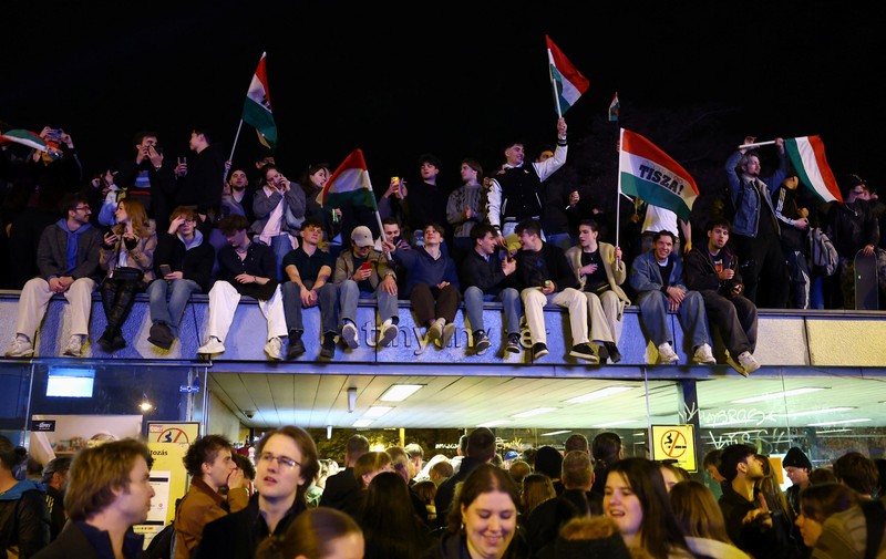 Sebuah tayangan drone menunjukkan orang-orang berkumpul untuk merayakan kemenangan di seberang Sungai Danube dari gedung Parlemen, setelah hasil sebagian pemilihan parlemen diumumkan, di Budapest, Hongaria, 12 April 2026. (REUTERS/Stringer)
