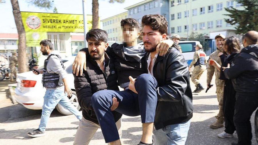 This handout photograph taken and released on April 14, 2026 by Turkish news agency DHA (Demiroren News Agency) shows an injured student evacuated as special force security surround the school in southeastern Turkey. Special security forces, who have been deployed to the school in the Siverek district of Sanliurfa province, evacuated the students, while efforts to convince the attacker to surrender were under way, private broadcaster NTV reported. (Photo by Handout / DHA (Demiroren News Agency) / AFP) / Turkey OUT / RESTRICTED TO EDITORIAL USE - MANDATORY CREDIT "AFP PHOTO /  DHA (Demiroren News Agency) " - NO MARKETING NO ADVERTISING CAMPAIGNS - DISTRIBUTED AS A SERVICE TO CLIENTS