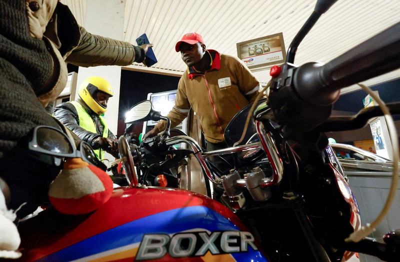 A fuel pump attendant confirms a mobile phone payment as he fuels a motorcycle taxi at a TotalEnergies petrol station ahead of an announced fuel price hike, as fuel costs rise amid global disruptions caused by the Iran war, in Nairobi, Kenya April 14, 2026. REUTERS/Thomas Mukoya