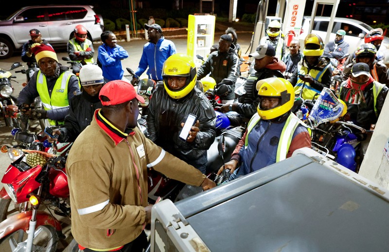 A fuel pump attendant confirms a mobile phone payment as he fuels a motorcycle taxi at a TotalEnergies petrol station ahead of an announced fuel price hike, as fuel costs rise amid global disruptions caused by the Iran war, in Nairobi, Kenya April 14, 2026. REUTERS/Thomas Mukoya