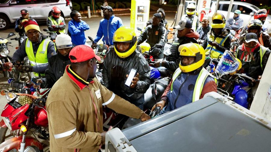 A fuel pump attendant confirms a mobile phone payment as he fuels a motorcycle taxi at a TotalEnergies petrol station ahead of an announced fuel price hike, as fuel costs rise amid global disruptions caused by the Iran war, in Nairobi, Kenya April 14, 2026. REUTERS/Thomas Mukoya