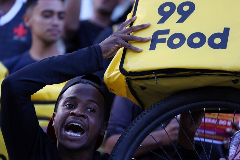 Para pekerja pengiriman barang melakukan protes menuntut perbaikan kondisi kerja dan menentang rancangan undang-undang yang mengatur pekerjaan berbasis aplikasi, yang menurut mereka akan merusak keamanan kerja dan menguntungkan perusahaan teknologi, di Sao Paulo, Brasil, 14 April 2026. (REUTERS/Amanda Perobelli)