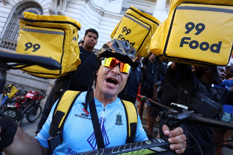 Para pekerja pengiriman barang melakukan protes menuntut perbaikan kondisi kerja dan menentang rancangan undang-undang yang mengatur pekerjaan berbasis aplikasi, yang menurut mereka akan merusak keamanan kerja dan menguntungkan perusahaan teknologi, di Sao Paulo, Brasil, 14 April 2026. (REUTERS/Amanda Perobelli)