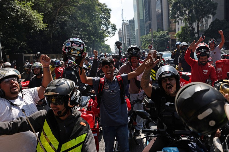 Para pekerja pengiriman barang melakukan protes menuntut perbaikan kondisi kerja dan menentang rancangan undang-undang yang mengatur pekerjaan berbasis aplikasi, yang menurut mereka akan merusak keamanan kerja dan menguntungkan perusahaan teknologi, di Sao Paulo, Brasil, 14 April 2026. (REUTERS/Amanda Perobelli)