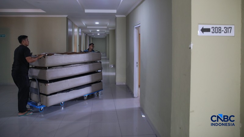 Petugas merapikan tempat tidur pada kamar calon jemaah haji di Asrama Haji Pondok Gede, Jakarta, Rabu (15/4/2026). (CNBC Indonesia/Faisal Rahman)