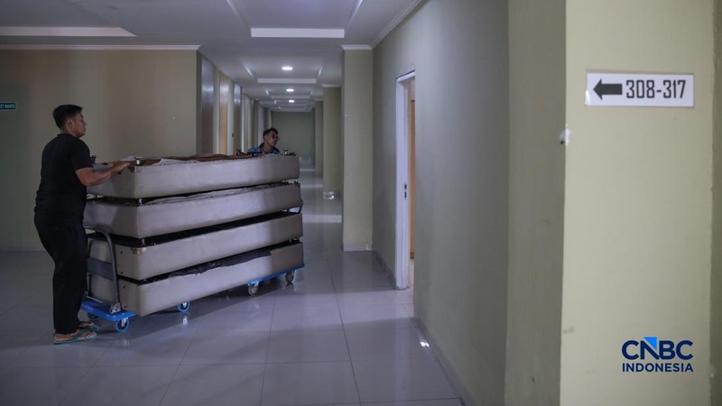 Petugas merapikan tempat tidur pada kamar calon jemaah haji di Asrama Haji Pondok Gede, Jakarta, Rabu (15/4/2026). (CNBC Indonesia/Faisal Rahman)