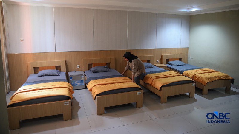 Petugas merapikan tempat tidur pada kamar calon jemaah haji di Asrama Haji Pondok Gede, Jakarta, Rabu (15/4/2026). (CNBC Indonesia/Faisal Rahman)