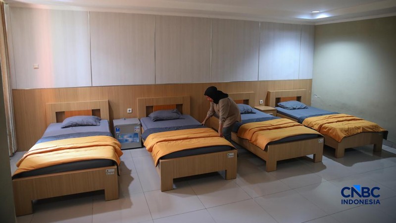 Petugas merapikan tempat tidur pada kamar calon jemaah haji di Asrama Haji Pondok Gede, Jakarta, Rabu (15/4/2026). (CNBC Indonesia/Faisal Rahman)
