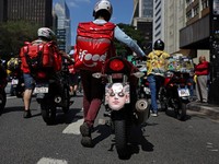 Seorang pria mendorong sepeda motornya dengan masker wajah bergambar Presiden Dewan Perwakilan Rakyat Brasil, Hugo Motta, terpasang selama protes para pekerja pengiriman barang untuk perbaikan kondisi kerja dan menentang rancangan undang-undang yang